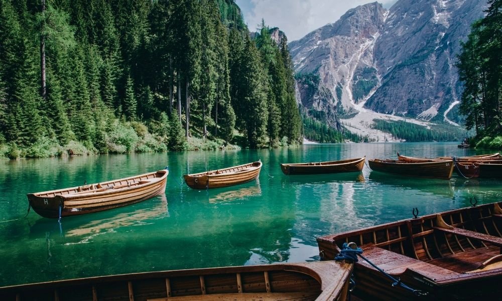 Lake Braies Pragser Wildsee at dawn with red rowboat and Dolomite mountain reflection, South Tyrol Italy