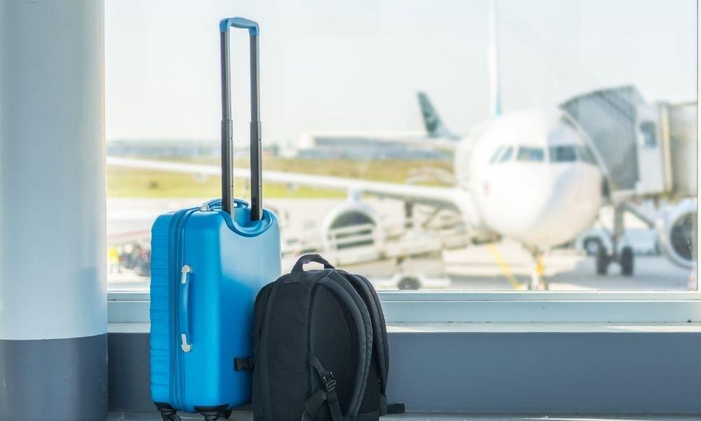 40L carry-on backpack next to oversized rolling suitcase for size comparison, minimalist product photography