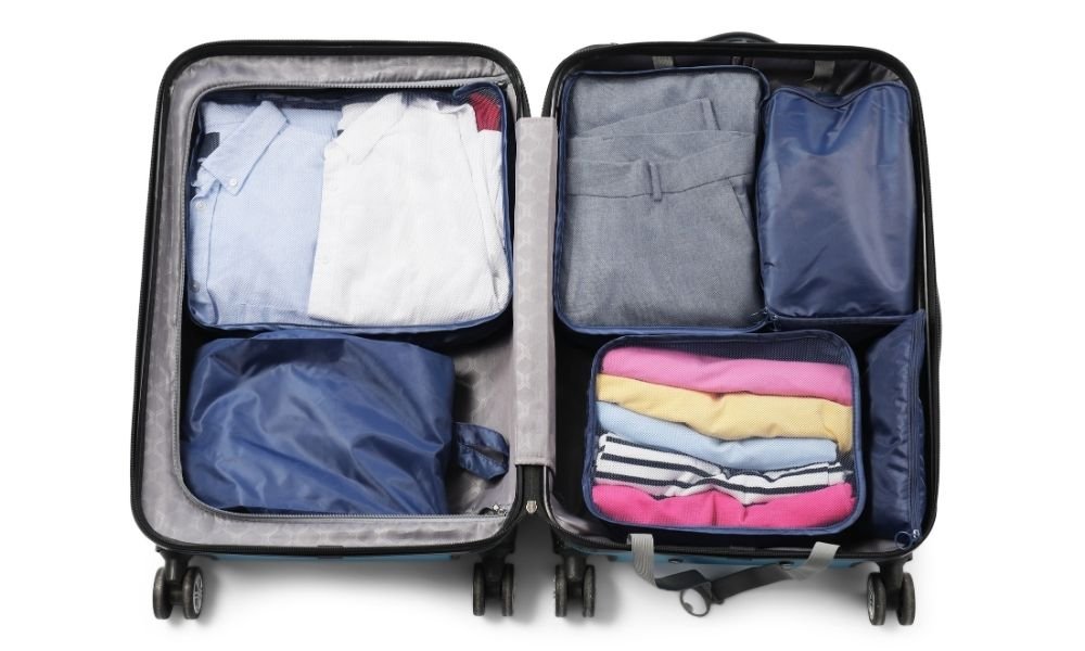 Compression packing cubes in various sizes stacked neatly inside an open carry-on suitcase