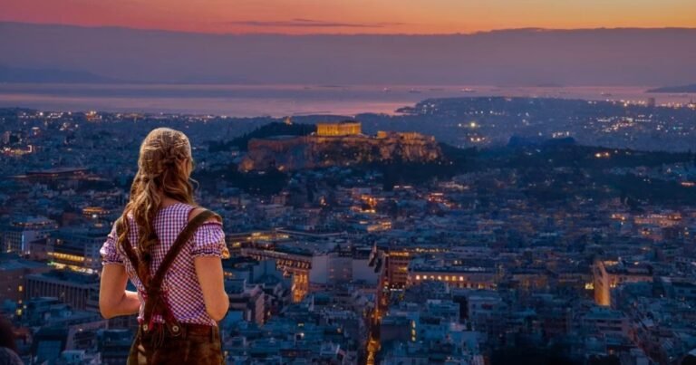 Solo traveler looking out over a scenic city skyline at sunset, representing the freedom of a first solo trip.