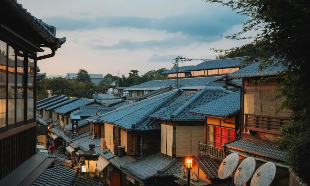 Traditional wooden machiya houses along a quiet street in Kyoto's Gion district with sliding doors and lattice windows