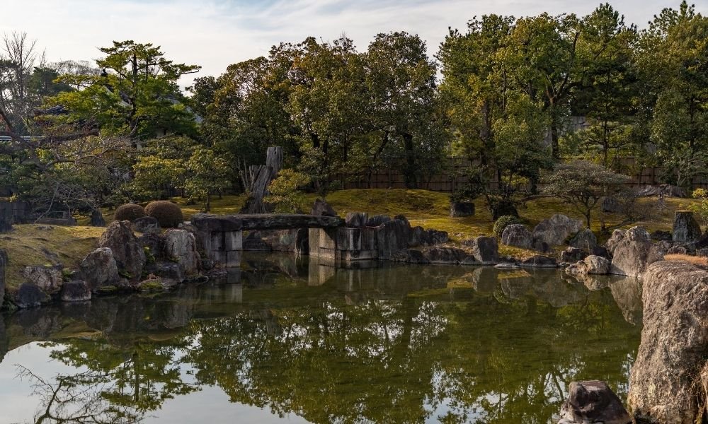 Nijo Castle gardens in Kyoto with a large pond, carefully placed rocks, and traditional Japanese landscaping