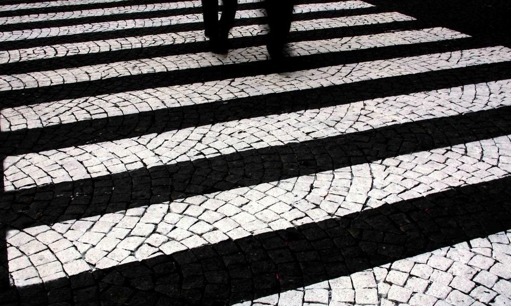 Traditional calçada portuguesa cobblestone pavement in Lisbon with walking shoes