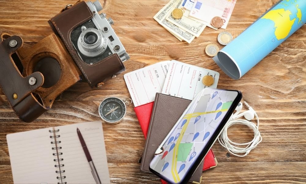 A smartphone displaying a digital map app next to a passport on a wooden table, emphasizing pre-trip travel planning.