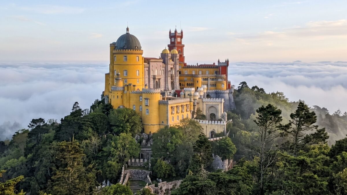 Colorful Pena Palace in Sintra above the clouds, a must-see on any Portugal travel itinerary