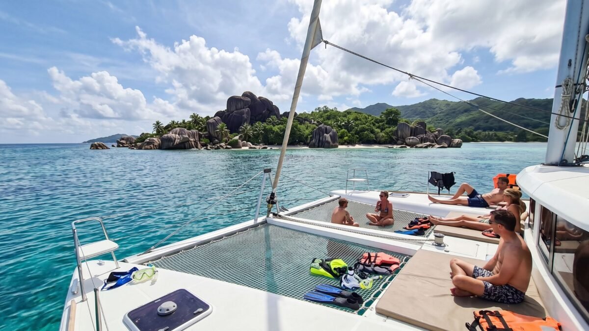 Island-hopping catamaran sailing between the granite islands of Seychelles